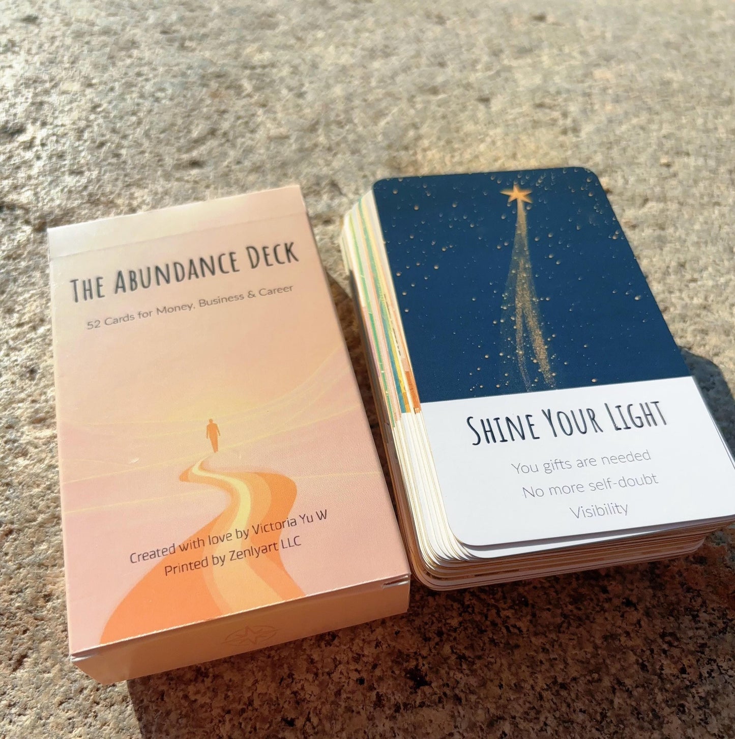 Abundance Deck cards with a card titled 'Shine Your Light' on a textured surface