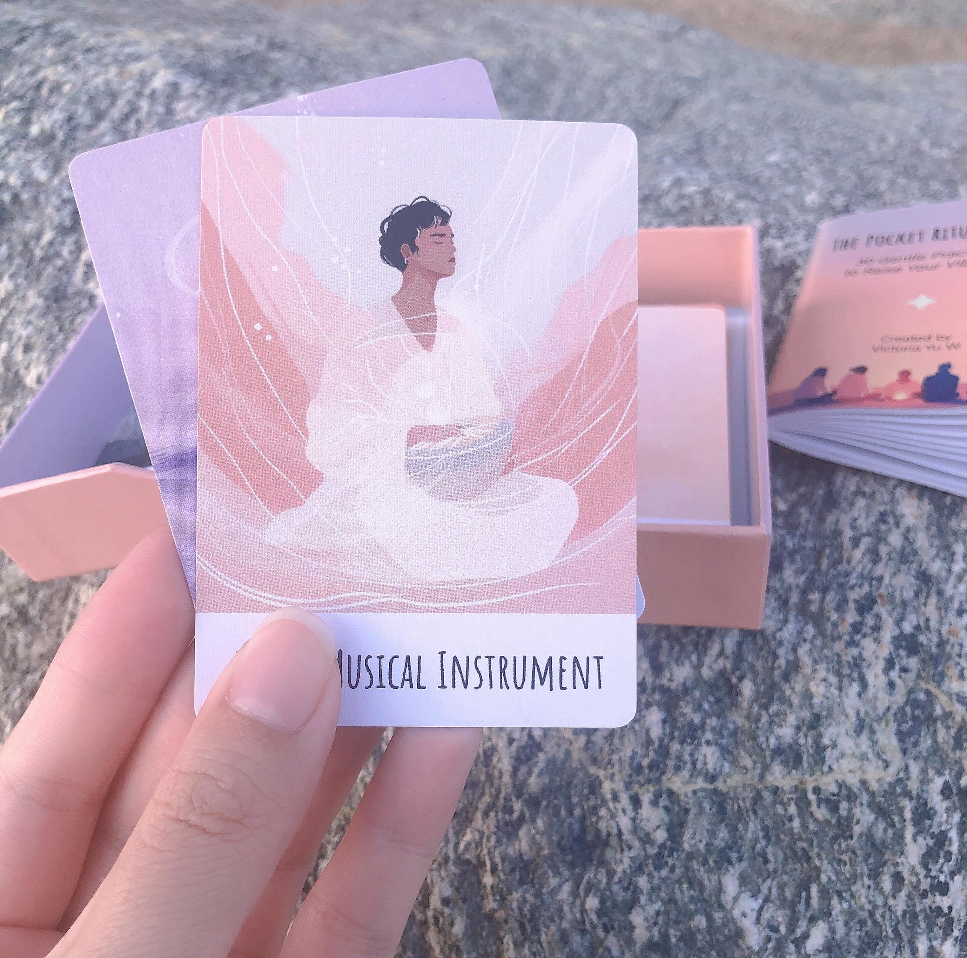 Card with a person in a white outfit and 'Musical Instrument' text held by a hand on a textured surface.