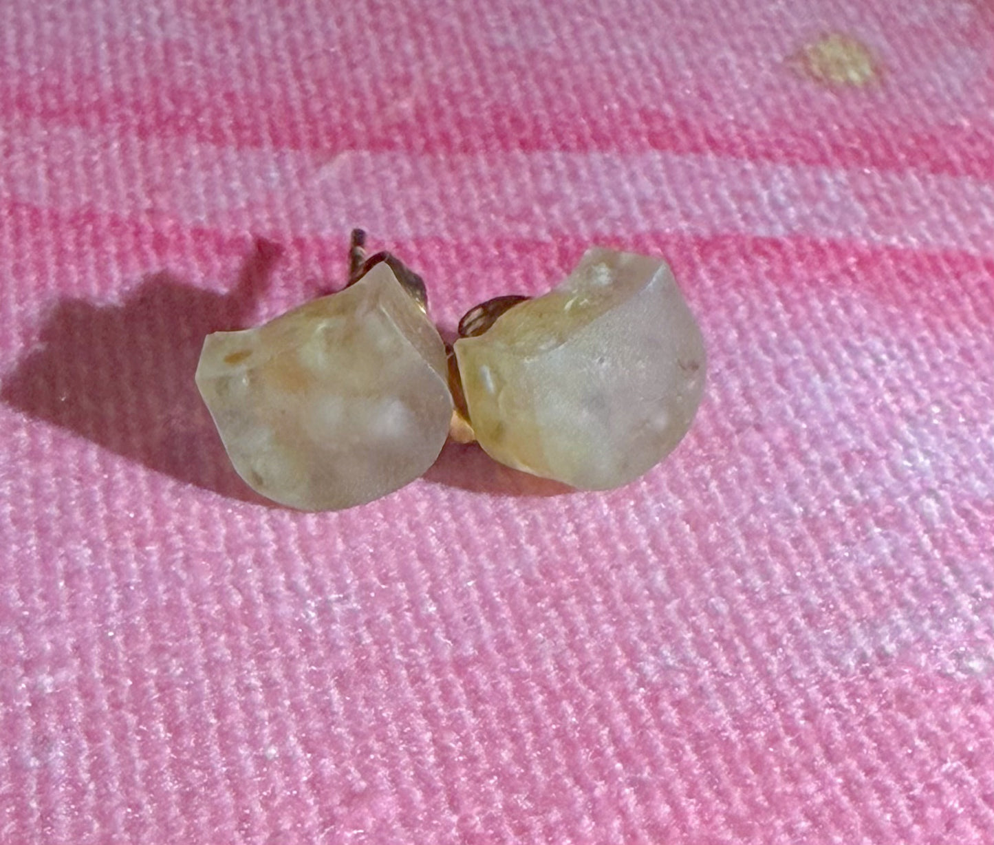Close-up of small peridot stud earrings with soft green tone and natural inclusions