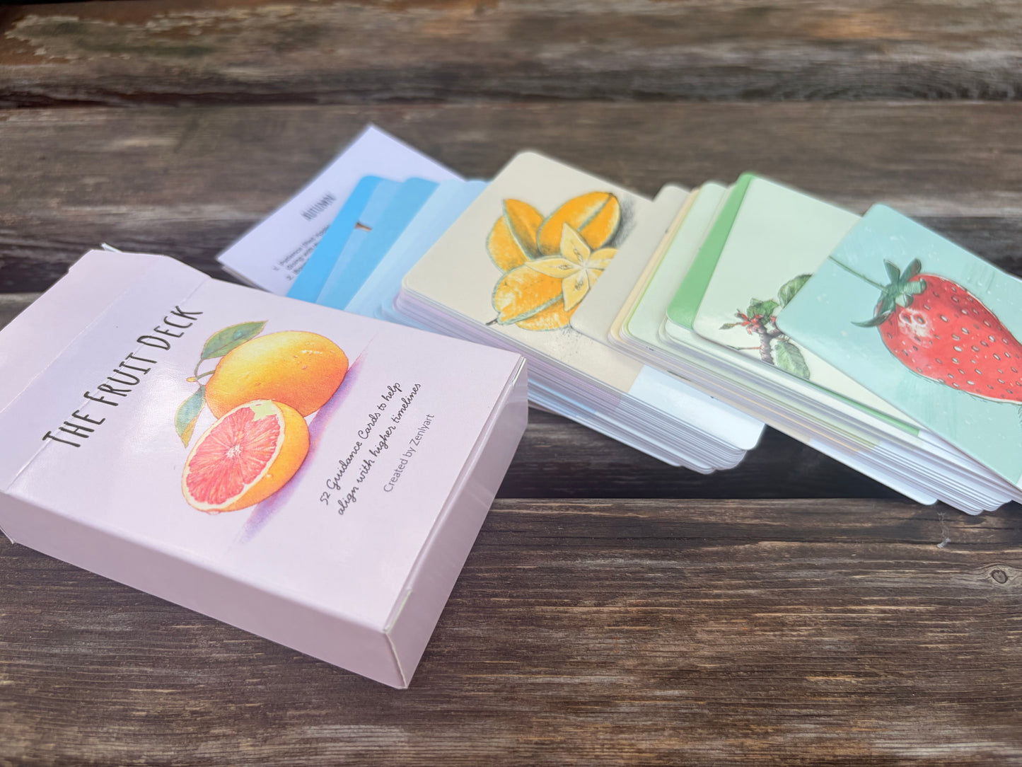 Complete 52-card Fruit Deck oracle deck arranged by seasonal color collections with storage box.