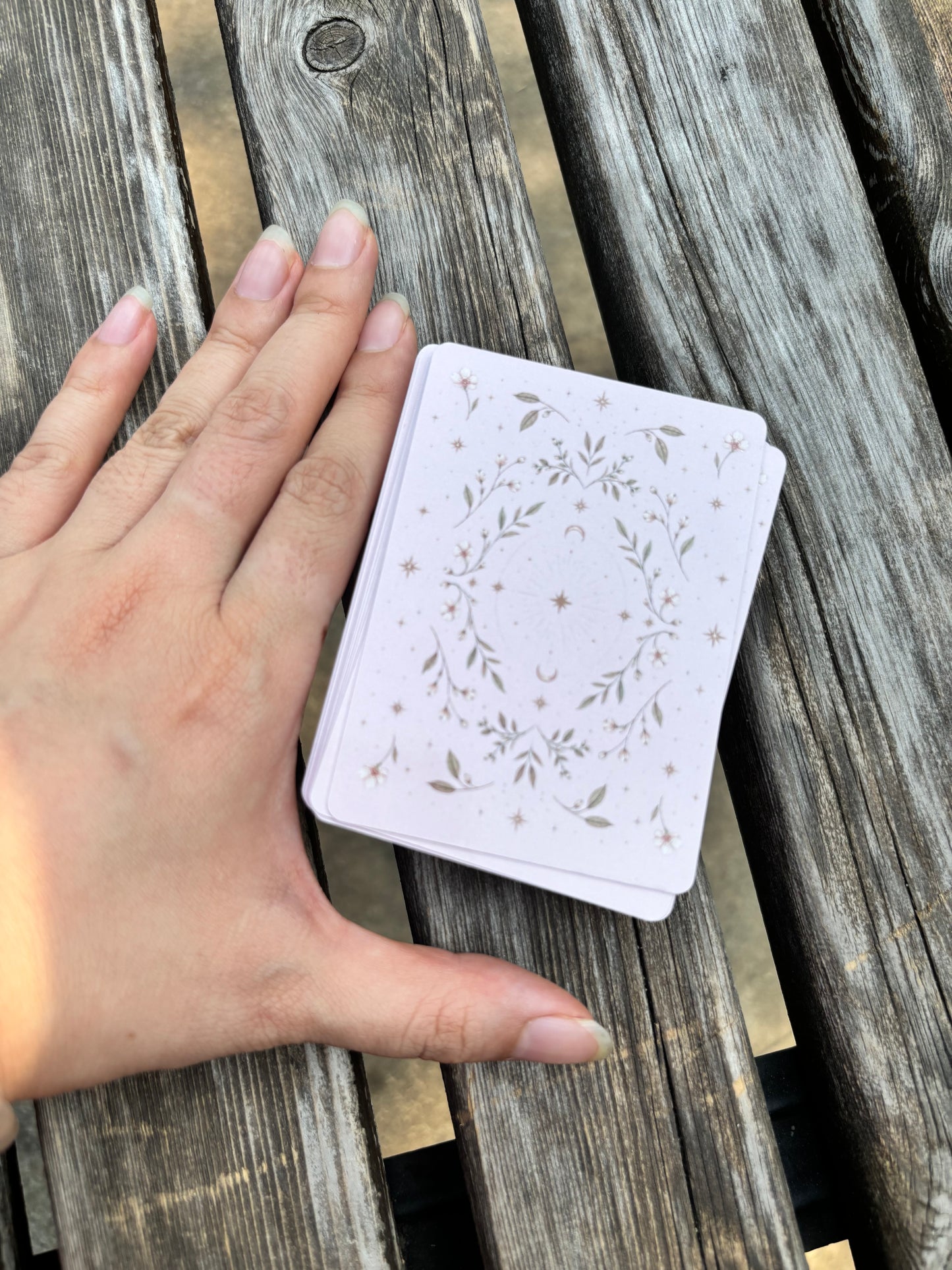 Hand next to The Fruit Deck to show poker-size oracle card dimensions and portability.