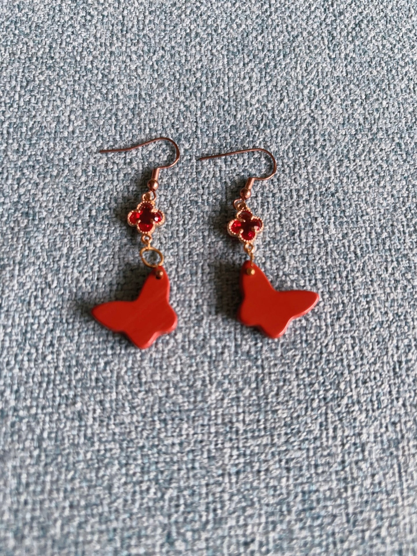 Handmade red jasper butterfly earrings with gold clover charm and hook design