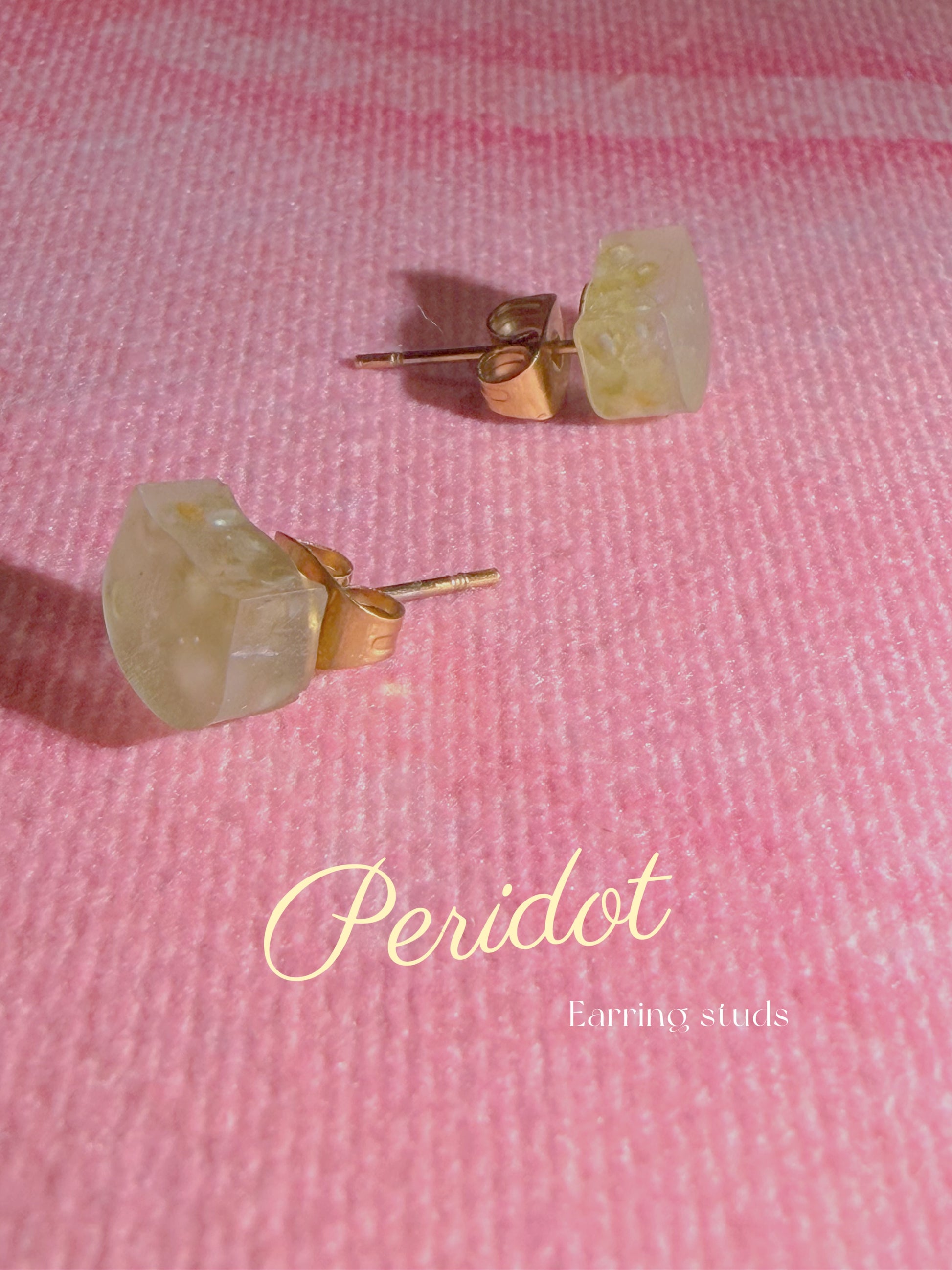 Peridot resin stud earrings on pink background with stainless steel posts