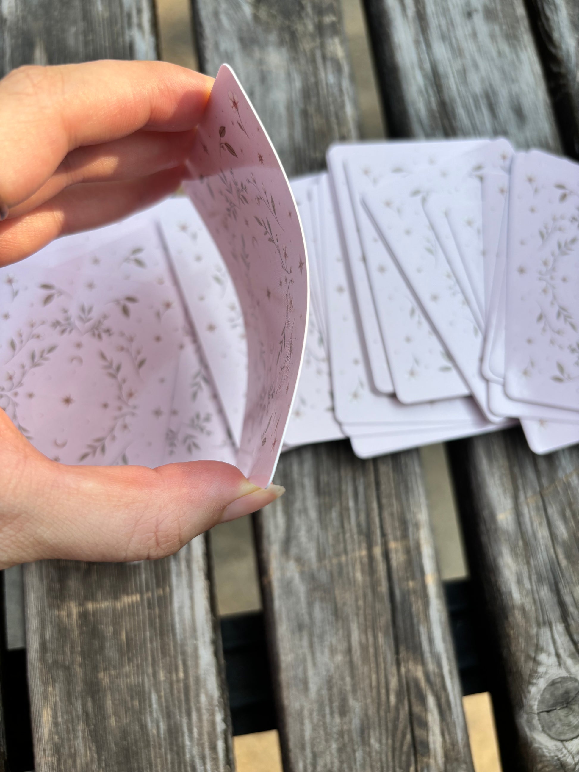 Person shuffling The Fruit Deck oracle cards featuring glossy finish and illustrated card backs.