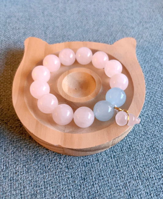Rose quartz aquamarine bracelet on wooden tray top view
