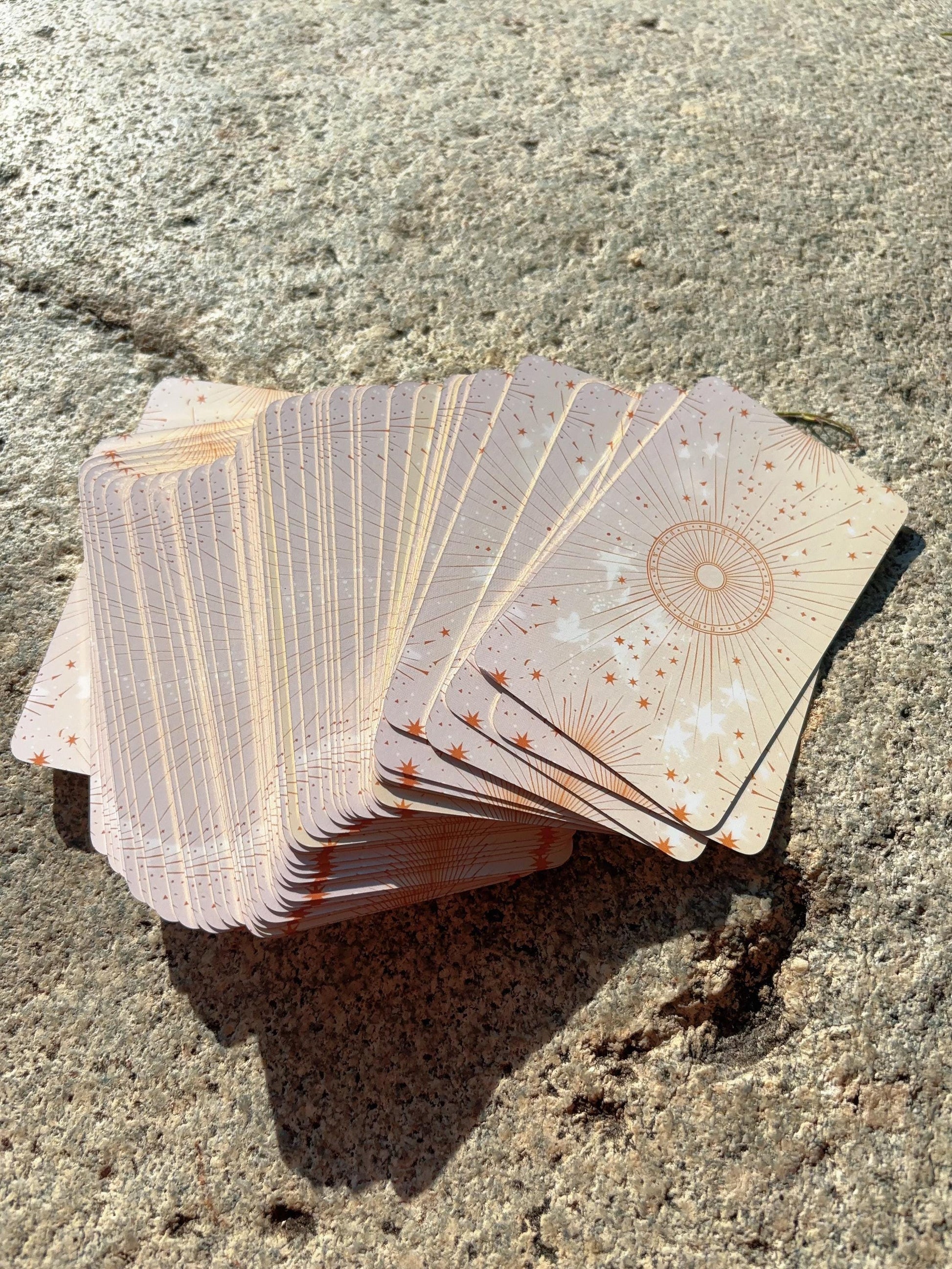 abundance oracle cards spread out in a fan arrangement on stone surface