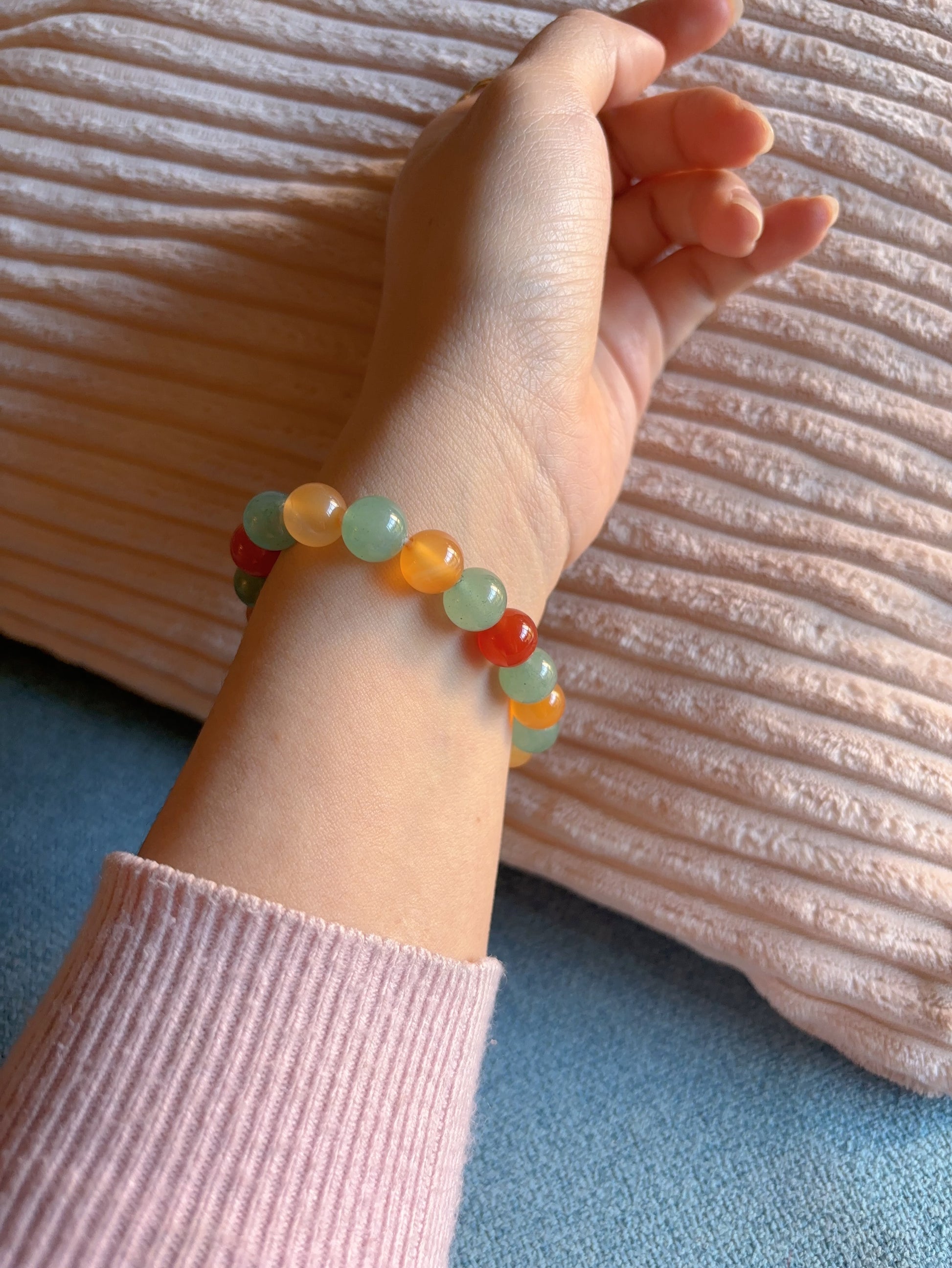 close up of aventurine and red agate bracelet on wrist with amethyst detai