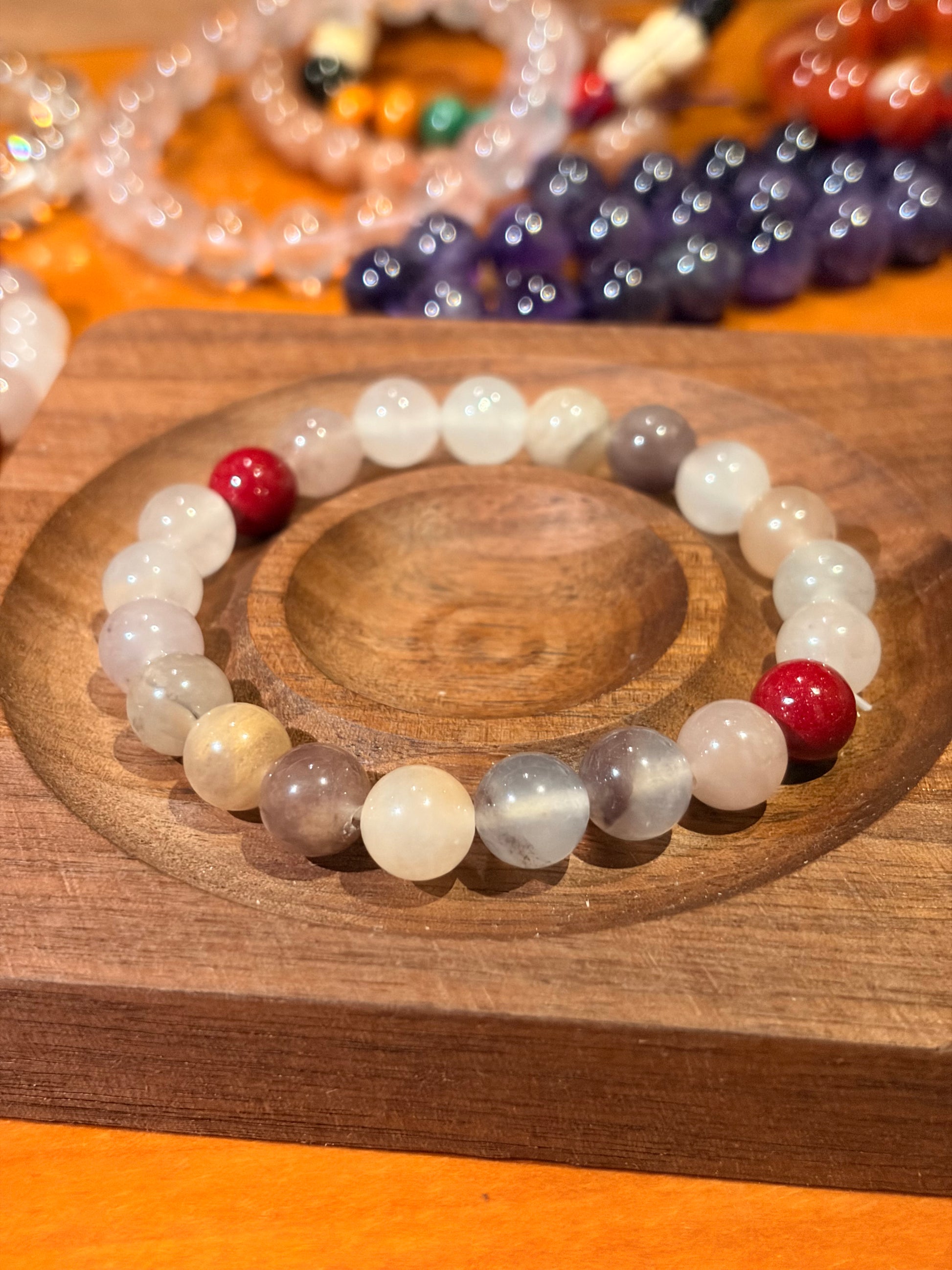 lavender jade and cinnabar bracelet on wooden tray soft warm light
