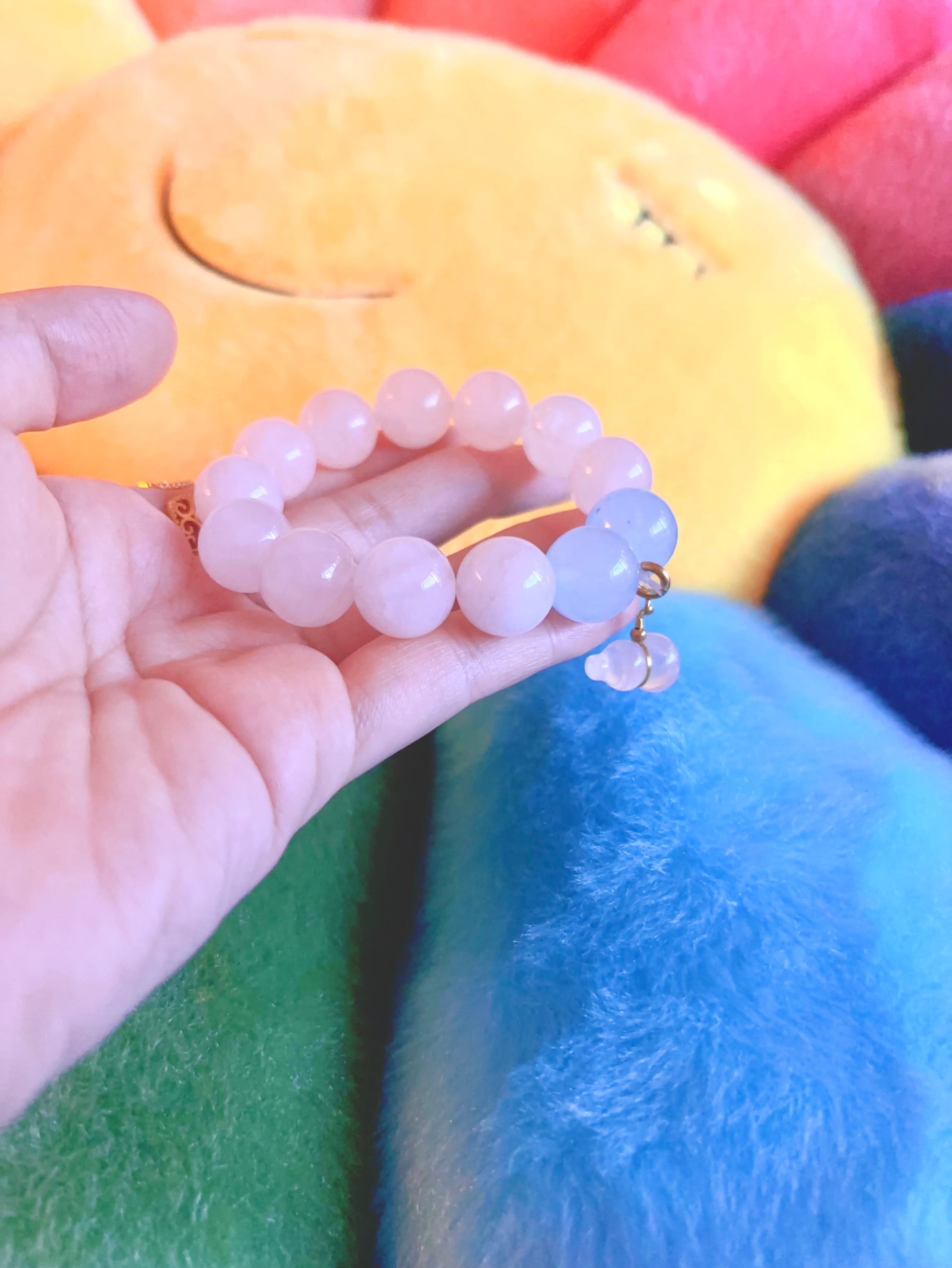 rose quartz aquamarine bracelet in hand colorful background